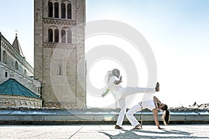 Pair of capoeira performers doing a kicking