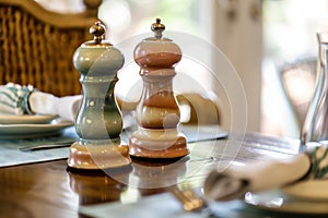 pair of ceramic pepper and salt mills on a dining table