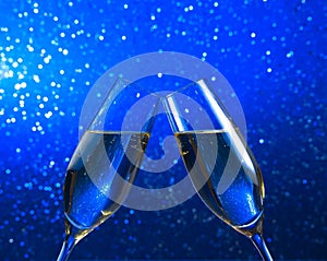 A pair of champagne flutes on blue light bokeh background