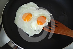 Pair of chicken eggs being fried in a fry pan