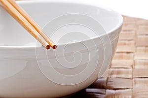 A pair of chopsticks on a white bowl