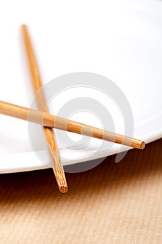 A pair of chopsticks on a white plate