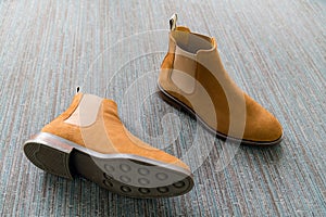 Pair of classic brown leather grooms shoes on the carpet photographed from above. Man fashion footwear background