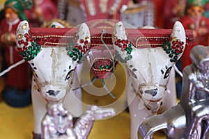 a pair of clay bullocks in a royal collection of colorful dolls