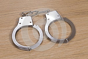 Pair of close handcuffs on wood