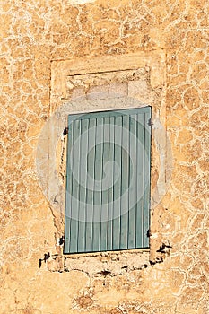 Pair of, closed, gray, tall, window shudders on, an 1800s building photo