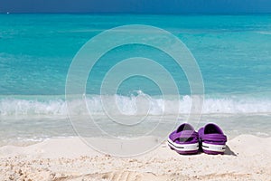 Pair of colored sandals on a white sand beach