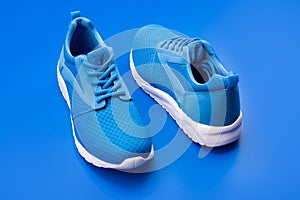 pair of comfortable blue sport shoes on blue background, shoe store