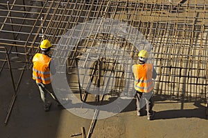 Construction workers attaching rebar photo