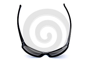 Pair of cool, macho, masculine, black sun glasses resting on lenses, bottom view on white background
