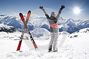 Pair of cross skis with woman skier, hands up