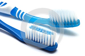A pair of dark blue toothbrushes against a white backdrop
