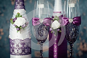 A pair of decorative purple champagne bottles and glasses for the bride and groom