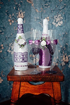 A pair of decorative purple champagne bottles and glasses for the bride and groom