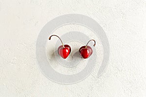 Pair of deformation ugly cherries in the heart shape flat lay on a white background. Zero waste concept. Imperfect, malformation