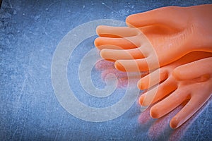 Pair of dielectric rubber gloves on metallic background electric photo