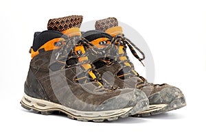 Pair of dirty brown/orange men`s hiking boots with white background.