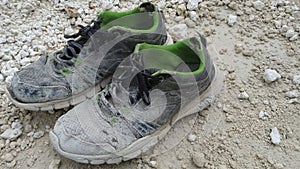 A pair of dirty old laborers\' shoes lay on the white limestone.