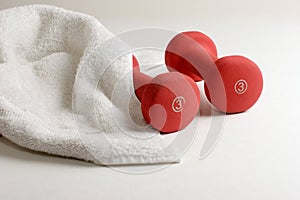 A pair of dumbbells and sweat towel