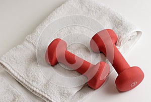 A pair of dumbells and white towel photo