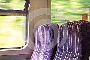 Pair of empty railway carriage seats seen on a commuter journey.