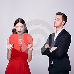 A pair of ex-lovers with a broken red heart on a white background