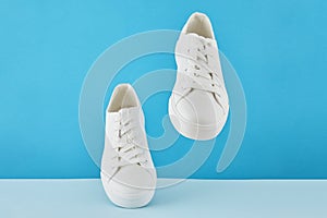 Pair of fashion stylish white sneakers, Running sports shoes on pastel blue background