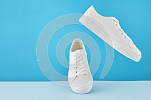 Pair of fashion stylish white sneakers, Running sports shoes on pastel blue background