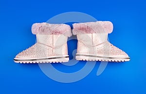 pair of fashionable leather ugg boots. ankle boots on blue background. shoe store.