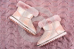 pair of fashionable leather ugg boots. ankle boots on knitted background. shoe store
