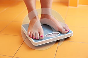 A pair of female feet on a bathroom scale