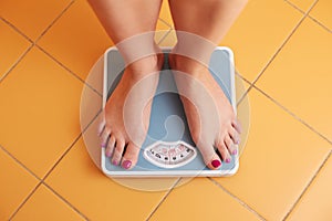 A pair of female feet on a bathroom scale