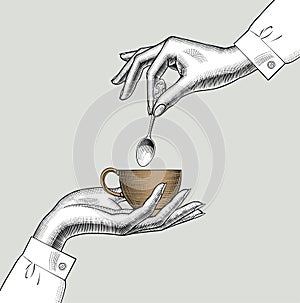 Pair of female hands with a coffee cup and spoon