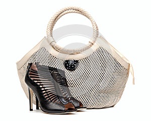 Pair of female shoes and handbag over white