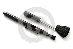 A pair of fixed and retractable black bristled brushes for cameras use white backdrop