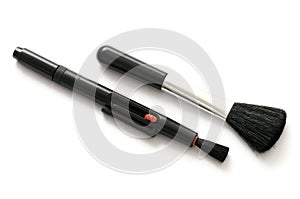 A pair of fixed and retractable black bristled brushes for cameras use white backdrop photo