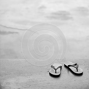 PAIR OF FLIP FLOPS ON CONCRETE GROUND