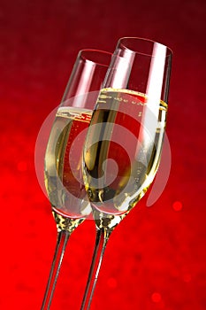 A pair of flutes of champagne red abstract background