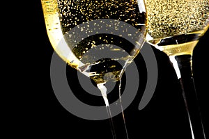 A pair of flutes of champagne tilted with golden bubbles