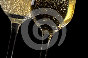 A pair of flutes of champagne tilted with golden bubbles