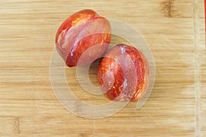 Pair of Amigo Pluots on a Wood Chopping Board photo