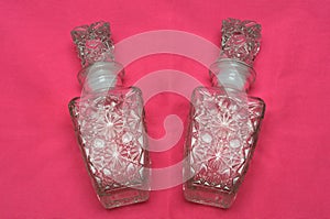 A pair of glass fluid bottles with floral patterns
