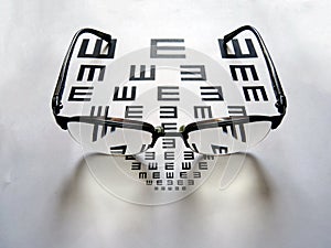 A pair of glasses and eye test chart