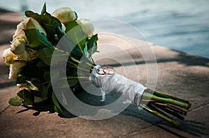 A pair of gold wedding rings on a bride& x27;s bouquet with white flowers