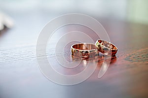 A pair of gold wedding rings on a brown background. Wedding rings on wooden background