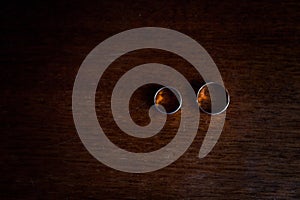 A pair of gold wedding rings on a brown background. Wedding rings on wooden background