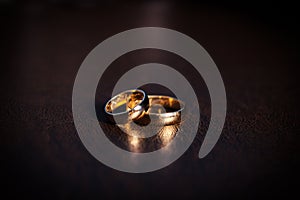 A pair of gold wedding rings, classic gold rings, on a dark background