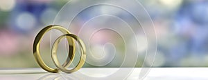 Two golden wedding rings isolated on white table, blur background, banner, copy space, 3d illustration