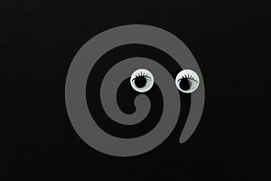 Pair googly eyes over black background