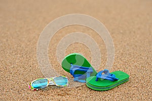 A pair of green and blue flip flops with colorful sunglasses